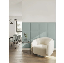 Salon moderne avec panneaux muraux carrés, fauteuil blanc en bouclé, table d'appoint avec vase et coin repas en arrière-plan.