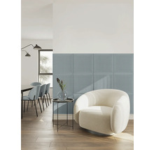 Panneaux muraux rembourrés carrés en tissu bleu dans un salon lumineux de style moderne avec un fauteuil blanc et un parquet en bois.