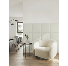 Aménagement intérieur moderne et lumineux avec panneaux muraux carrés, un fauteuil bouclé rond et un coin repas à l'arrière-plan.