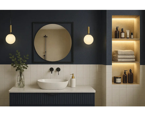 Modernes Badezimmer mit weißem Aufsatzwaschbecken, dunkelblauem Unterschrank, rundem Spiegel und beleuchteter Wandnische.