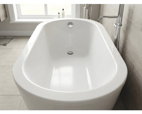 Freistehende Badewanne in ovaler Form in einem hellen, modernen Badezimmer mit einer Standarmatur aus Chrom.