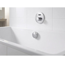 Unterputz-Badearmatur und Überlaufgarnitur aus Chrom an einer weißen Badewanne in einem hellen, organisierten Badezimmer.