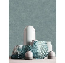 Papier peint intissé avec une structure textile fine bleu-vert, décoré de divers vases en céramique et en verre.