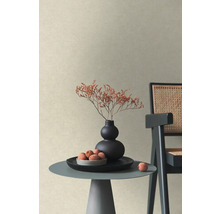 Papier peint intissé structuré beige dans une pièce moderne avec table basse, vase de fleurs séchées et chaise.