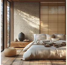 Chambre lumineuse de style japonais avec papier peint à motifs, lit bas en bois, pouf en rotin et panneaux muraux en fibres naturelles.