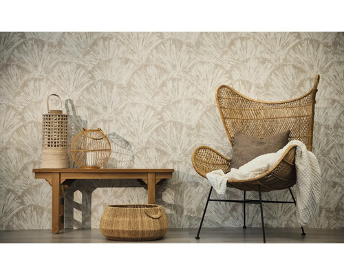 Salon avec papier peint intissé à motif d'éventail, fauteuil en rotin avec plaid, banc en bois avec lanternes et un panier tressé au sol.