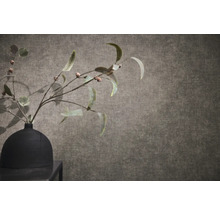 Papier peint texturé aspect lin avec un vase noir et des branches au premier plan.