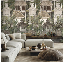 Salon avec canapé gris et papier peint panoramique illustrant un paysage tropical avec des cabanes balinaises et des palmiers.