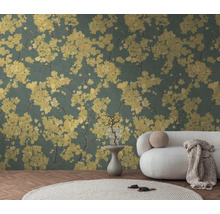 Papier peint avec motif floral jaune sur fond vert foncé dans un salon lumineux avec canapé blanc et tapis rond.