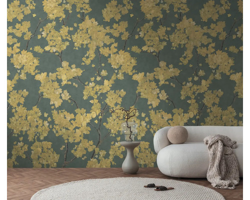 Papier peint avec motif floral jaune sur fond vert foncé dans un salon lumineux avec canapé blanc et tapis rond.