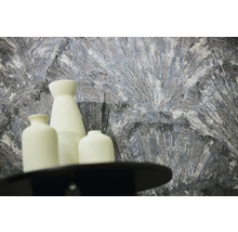 Papier peint texturé avec motif abstrait gris et blanc derrière trois vases blancs.