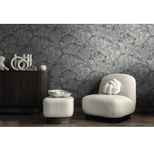 Pièce moderne avec papier peint gris texturé à motif d'éventail, buffet en bois sombre et fauteuil blanc avec coussin nœud.