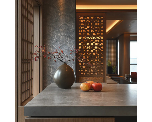 Intérieur moderne avec plan de travail aspect pierre, vase en céramique avec baies, pommes, mur texturé et séparateur de pièce décoratif en bois.