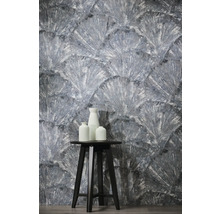 Papier peint texturé à motif d'éventail, avec un tabouret noir et trois vases blancs au premier plan.