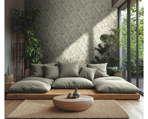 Salon lumineux avec papier peint intissé motif feuilles, canapé plateforme en bois, table ronde en bois, tapis en jute et plantes.