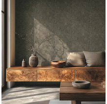 Salon moderne avec mur gris foncé structuré, buffet en bois, vases décoratifs, bol en bois et coussins à la lumière du jour.