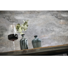 Mur aspect béton structuré avec décoration composée d'un verre de vin, d'un vase avec plante et d'un pot sur une étagère en bois.