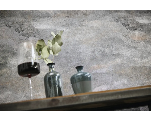 Mur aspect béton structuré avec décoration composée d'un verre de vin, d'un vase avec plante et d'un pot sur une étagère en bois.