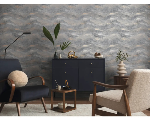 Salon moderne avec papier peint gris à motifs de vagues, buffet foncé, fauteuils texturés et décoration minimaliste.