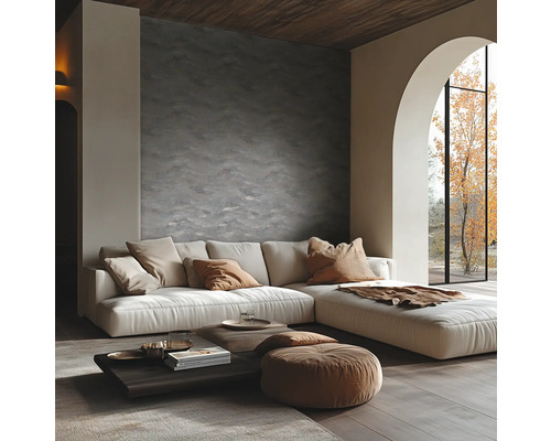 Salon moderne avec un mur texturé, un canapé d'angle, une table basse en bois et une grande fenêtre voûtée donnant sur un arbre.