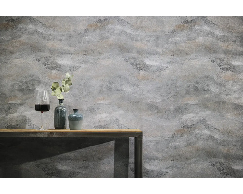 Papier peint intissé structuré à aspect pierre sur un mur derrière une table en bois avec des vases décoratifs et un verre de vin.