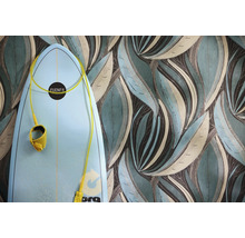 Papier peint à grand motif de feuilles stylisées en bleu-vert et brun à côté d'une planche de surf bleu clair.