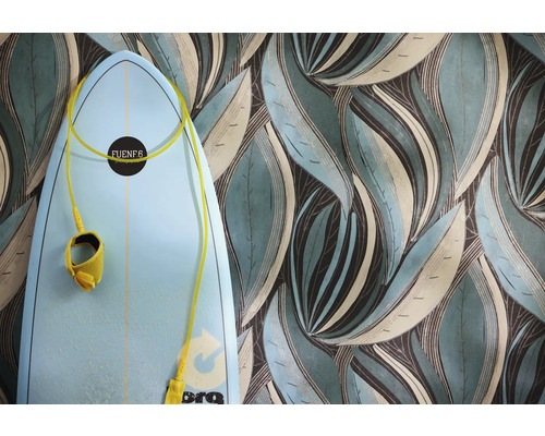 Papier peint à grand motif de feuilles stylisées en bleu-vert et brun à côté d'une planche de surf bleu clair.