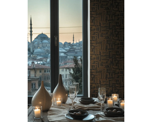 Table à manger dressée avec bougies, verres et vases devant une fenêtre avec vue sur la ville et papier peint à motifs géométriques.