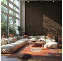 Salon moderne et lumineux avec papier peint à motifs sombres grand canapé d'angle blanc tapis d'orient coloré table en bois et grandes fenêtres.