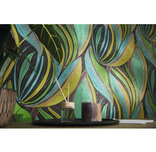 Papier peint intissé à motif de feuilles botaniques dans une scène de salon avec diffuseur et bougies.