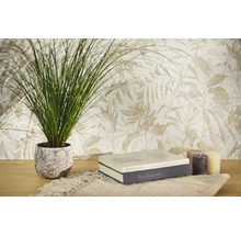 Papier peint intissé à motif botanique de feuilles en tons clairs, avec une plante verte, des livres et des bougies sur une table en bois.