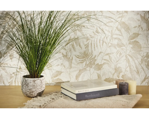 Papier peint intissé à motif botanique de feuilles en tons clairs, avec une plante verte, des livres et des bougies sur une table en bois.