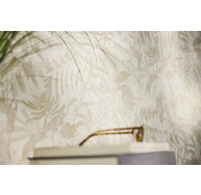 Papier peint intissé avec motif de feuilles tropicales et de fougères dans une pièce lumineuse.