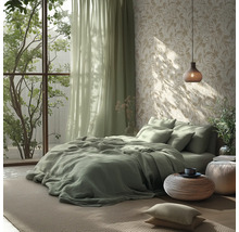Chambre lumineuse avec literie verte, papier peint à motif de feuilles, rideaux vert clair et suspension et poufs tressés.