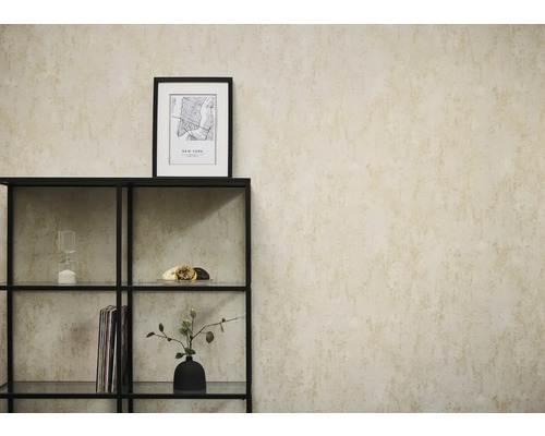 Papier peint intissé aspect béton beige sur un mur derrière une étagère en métal noir avec des objets décoratifs.
