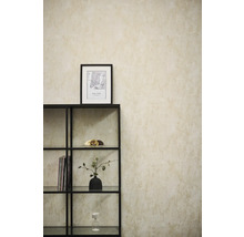 Papier peint intissé avec aspect structuré sur un mur derrière une étagère en métal noir dans une pièce lumineuse et moderne.