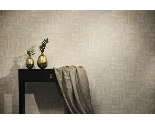 Vliestapete mit abstraktem geometrischem Muster in Beige, präsentiert in modernem Wohnambiente mit dunkler Konsole und Goldvasen.