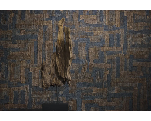 Vliestapete mit geometrischem Texturmuster in Weboptik vor einer dekorativen Holzskulptur.
