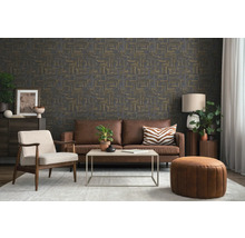 Wohnzimmer mit dunkler Tapete in abstrakter Optik, braunem Ledersofa, hellem Sessel, Couchtisch und Teppich in modernem Stil.