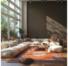 Geräumiges Wohnzimmer mit dunkler Vliestapete mit geometrischem Muster, weißem modularem Sofa, orientalischem Teppich und großen Fenstern.