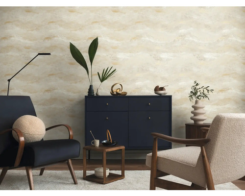Salon moderne avec papier peint à motif abstrait beige et doré, buffet bleu foncé et deux fauteuils.