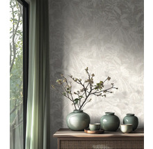 Papier peint intissé au motif de feuilles subtil dans une pièce lumineuse au design naturel avec buffet en bois et vases en céramique.