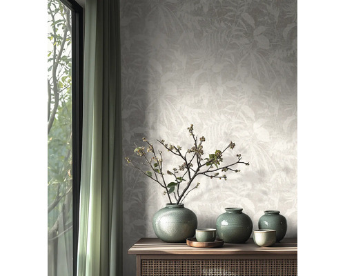 Papier peint intissé au motif de feuilles subtil dans une pièce lumineuse au design naturel avec buffet en bois et vases en céramique.