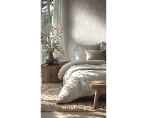 Chambre lumineuse avec papier peint intissé à motif de feuilles, lit en lin et table de chevet en tronc d'arbre.