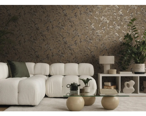 Un salon moderne avec un papier peint brun à motifs de feuilles, un canapé modulable blanc et une table basse en verre dans une ambiance chaleureuse.