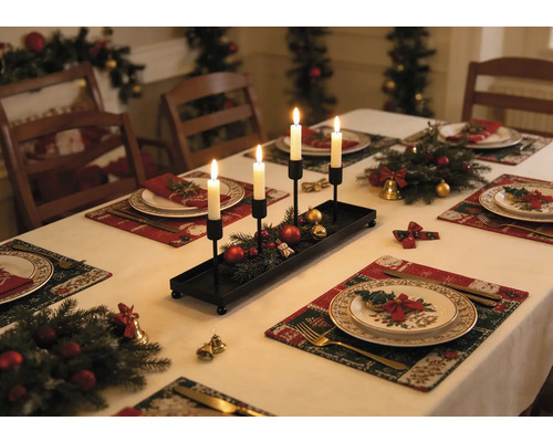 Bougeoir rectangulaire noir en métal avec quatre bougies blanches sur une table de Noël décorée de branches de sapin.
