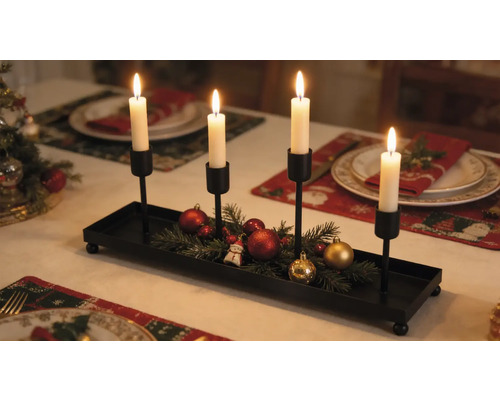 Porte-bougies de l'Avent en métal noir avec quatre bougeoirs, décoré de branches de sapin et de boules de Noël sur une table dressée pour les fêtes.