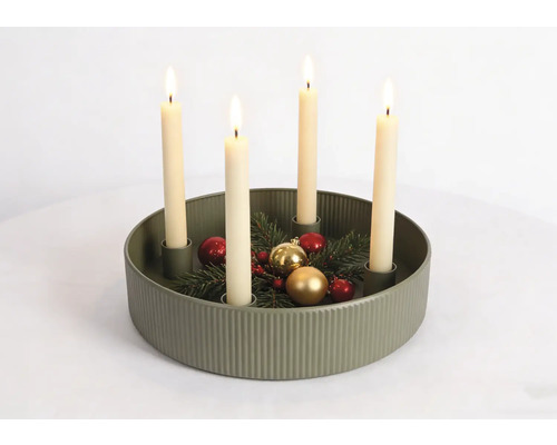 Bougeoir d'Avent rond vert olive à structure côtelée, quatre bougies allumées, branches de sapin et décorations de Noël.