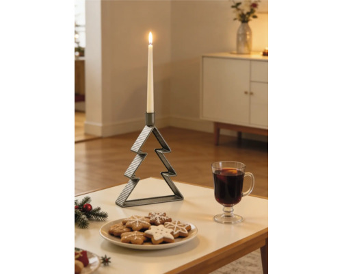 Chandelier nervuré en métal en forme de sapin de Noël avec une bougie blanche allumée sur une table à côté de biscuits et un verre de boisson chaude.