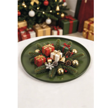 Plateau de Noël rond avec branches de sapin, petits cadeaux, cônes et clochettes dans une ambiance festive.